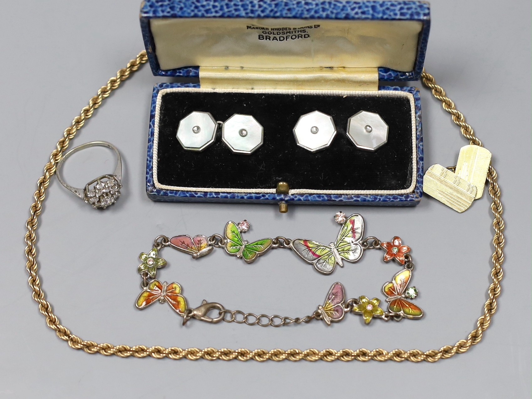 A modern 9ct gold rope twist chain, 5.2 grams, a white metal and enamel butterfly link bracelet, a pair of mother of pearl and base metal cufflinks in box, a gold plated cufflink and a silver dress ring.